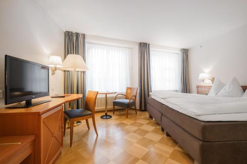 バーデンにあるHotel Blume - Swiss Historic Hotelのベッド1台、薄型テレビが備わるホテルルームです。