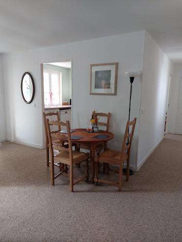 a dining room with a table and chairs and a clock at Stable Cottage at Orchard Farm in Combles