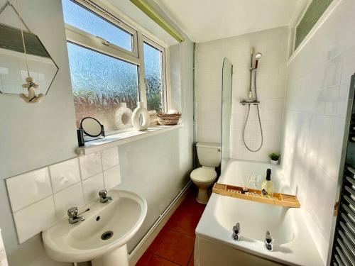 een witte badkamer met een wastafel en een toilet bij Southsea Garden Retreat in Portsmouth