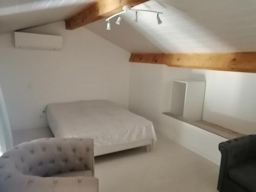 une chambre avec un lit et une chaise dedans dans l'établissement Provence Verte, à Forcalqueiret