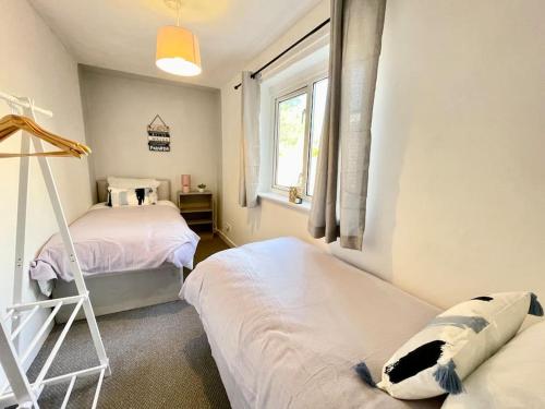 een slaapkamer met 2 bedden en een raam bij Southsea Garden Retreat in Portsmouth