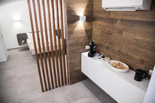 a bathroom with a wooden wall with a bowl of food on a counter at Il Cocchiere in Palagianello