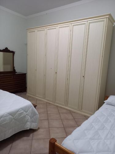 a bedroom with two beds and a large white closet at Casa Teresa in Tarquinia