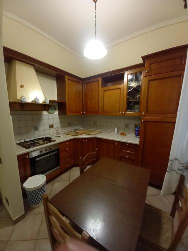 a kitchen with wooden cabinets and a wooden table with a table at Casa Teresa in Tarquinia