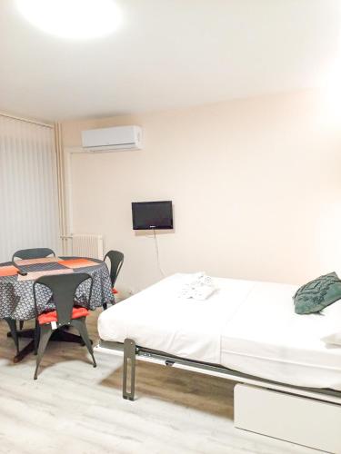 une chambre avec un lit, une table et une télévision dans l'établissement Rose Garden YourHostHelper, à Cagnes-sur-Mer
