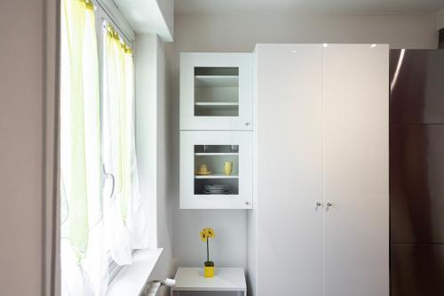 a room with a white cabinet and a window at Accogliente Monolocale in Porta Romana in Milan