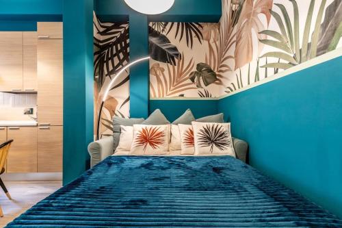 1 dormitorio con 1 cama con pared azul en Belmeloro Home en Bolonia