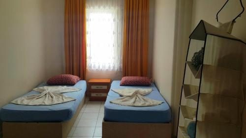 two beds in a small room with a window at SARIMSAKLI RİO BEACH KARŞISI DENİZE 0 DAİRE in Ayvalık