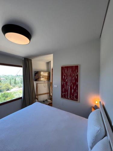 - une chambre avec un lit blanc et une fenêtre dans l'établissement Corto, à Leucade