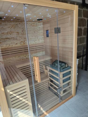 a sauna with wooden floors and a glass wall at Gîte des granges in Alençon