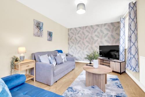 a living room with a couch and a tv at Contractors Retreat 3 bedroom house, sleeps up to 7, free parking in Milton Keynes