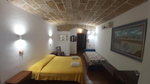 sypialnia z dużym żółtym łóżkiem w pokoju w obiekcie vibavacanze w mieście Palermo