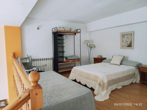 a bedroom with two beds and a chair in it at Apartamento Premium Relax C in Bárcena de Cicero