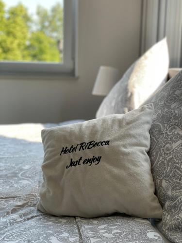 a pillow with the words hotel rebel rebel last exile sits on a bed at RiBecca in Weyhe