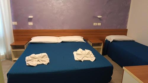 a bedroom with two beds with towels on them at Lugano Residence in Rimini