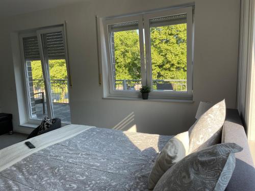 a bedroom with a bed and two windows at RiBecca in Weyhe