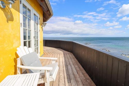 a balcony with two chairs and the ocean at Stammershalle Badehotel in Bådsted