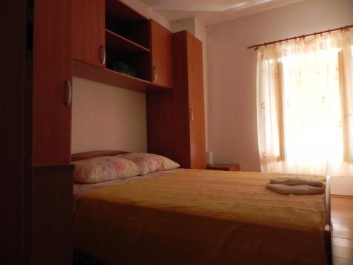 a bedroom with a large bed with a window at Apartments Riva in Pag