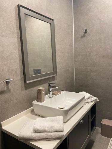 La salle de bains est pourvue d'un lavabo blanc et d'un miroir. dans l'établissement Luxry Apartment, à Istanbul