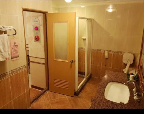 baño con lavabo, aseo y puerta en Huang Jia Hotel en Yongkang
