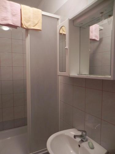 a bathroom with a sink and a mirror and a tub at Apartments Riva in Pag