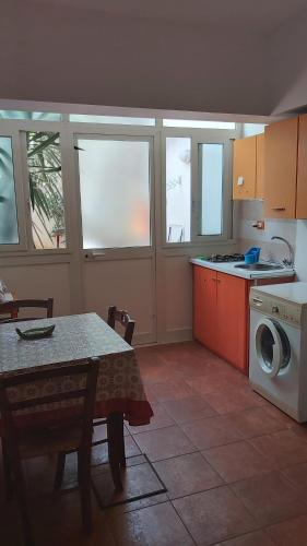 eine Küche mit einem Tisch und einer Waschmaschine in der Unterkunft vibavacanze in Palermo