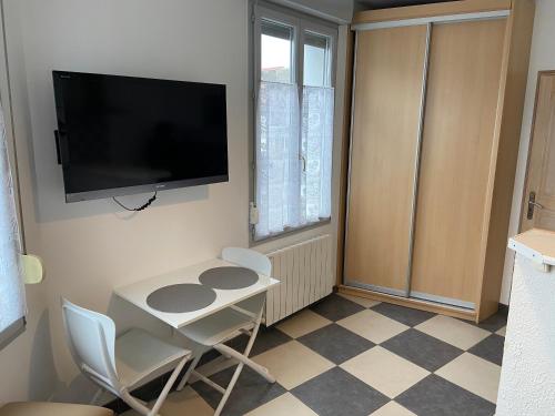 a small room with a table and a television on the wall at BERCK SUR MER in Berck-sur-Mer
