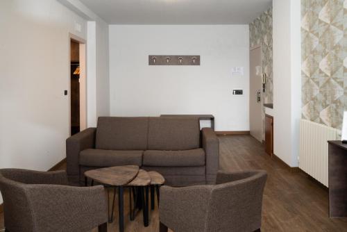 a living room with a couch and chairs and a table at Le Torri - Castiglione Falletto in Castiglione Falletto