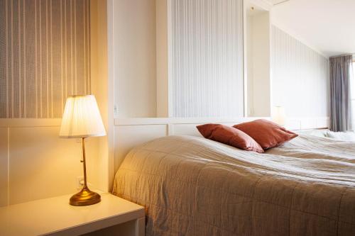 a bedroom with a bed with a lamp and a window at Stammershalle Badehotel in Bådsted