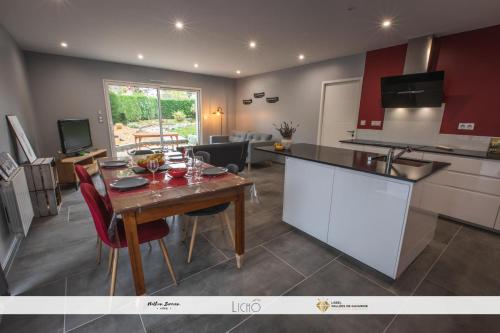 a kitchen and living room with a wooden table and chairs at Maison Lys in Argelès-Gazost