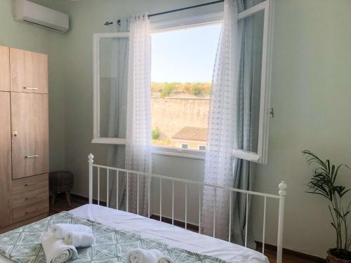 Corfu Fortress Apartment في Ágios Rókkos: غرفة نوم بسرير ونافذة