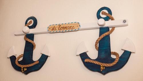 a wooden sign with two anchors on a wall at Le Tonnare in Portoscuso