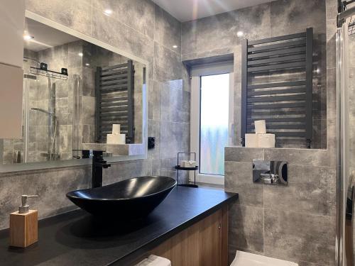 La salle de bains est pourvue d'un lavabo noir sur un comptoir. dans l'établissement Apartament Zielony Raj, à Wałbrzych