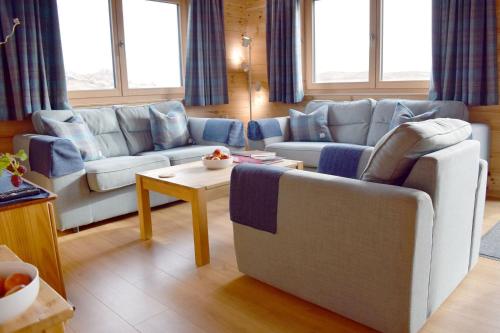 a living room with two couches and a table at Arran Lodge, Isle of Harris in Manish