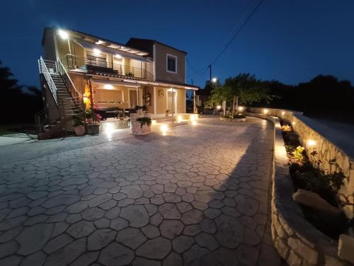 a house with a patio at night with lights at Villeta Nikol in Lixouri