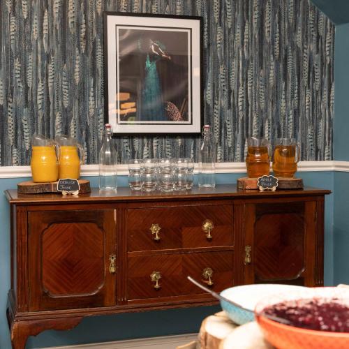 a table with glasses and a picture on a wall at Wisteria Hotel in Oakham