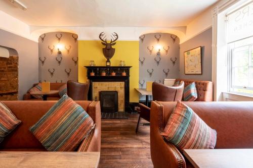 a living room with couches and a fireplace at Wisteria Hotel in Oakham