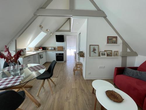 un salon avec un canapé rouge et une table dans l'établissement Le Verger de Sophie, à Sainte-Geneviève-lès-Gasny