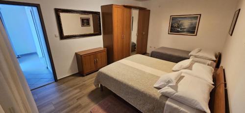 a small bedroom with a bed and a mirror at SOBE/ROOMS RIVA in Zadar