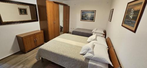 a bedroom with two beds and a cabinet and a mirror at SOBE/ROOMS RIVA in Zadar