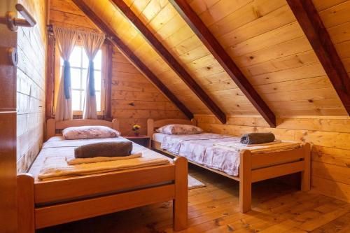 a bedroom with two beds in a wooden cabin at Green Hill in Virpazar