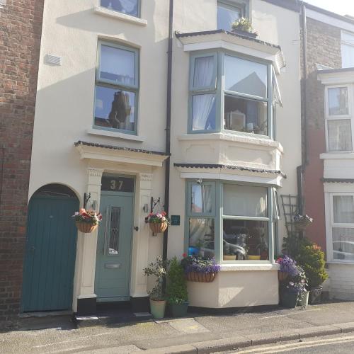 a white house with a green door and windows at The Holly & Ivy in Bridlington