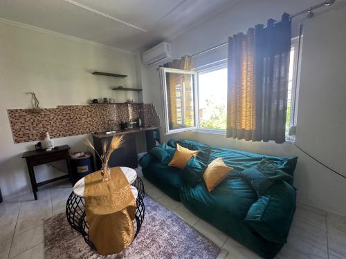 a living room with a green couch and a table at Koa Studio Apartment in Korçë