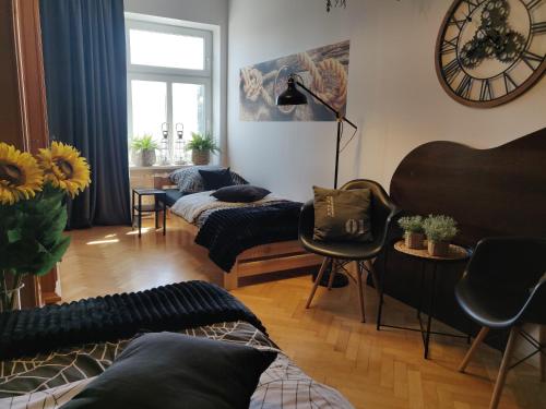 sala de estar con 2 camas y reloj en la pared en Szarotka, en Szczecin