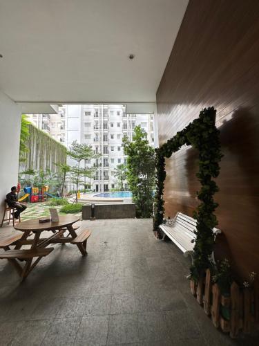 ジャカルタにあるSignature Park Grande Serviced Condominium LRT Jakarta 2BRのベンチ2台とブドウの木のアーチのある部屋