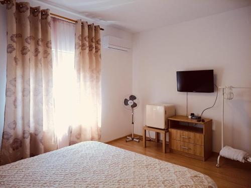 een slaapkamer met een bed, een tv en een raam bij Casa Wave Sound in Agigea