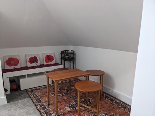 a table and two stools in a room at House of Bondol in Aberdeen