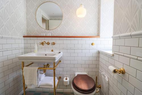 a bathroom with a sink and a toilet and a mirror at Stammershalle Badehotel in Bådsted