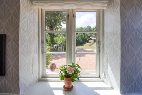 a window with a vase of flowers in a room at Stammershalle Badehotel in Bådsted
