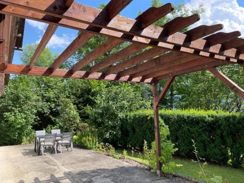 a wooden pergola with tables and chairs under it at Haus Silverfern in Förolach